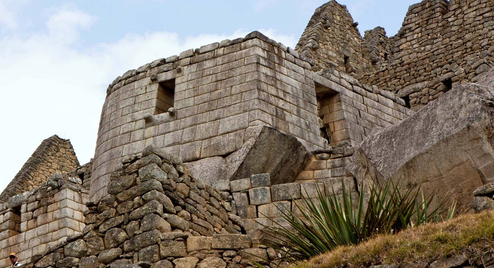 精確乾砌石牆的古代印加石造遺跡，在部分多雲的天空下。