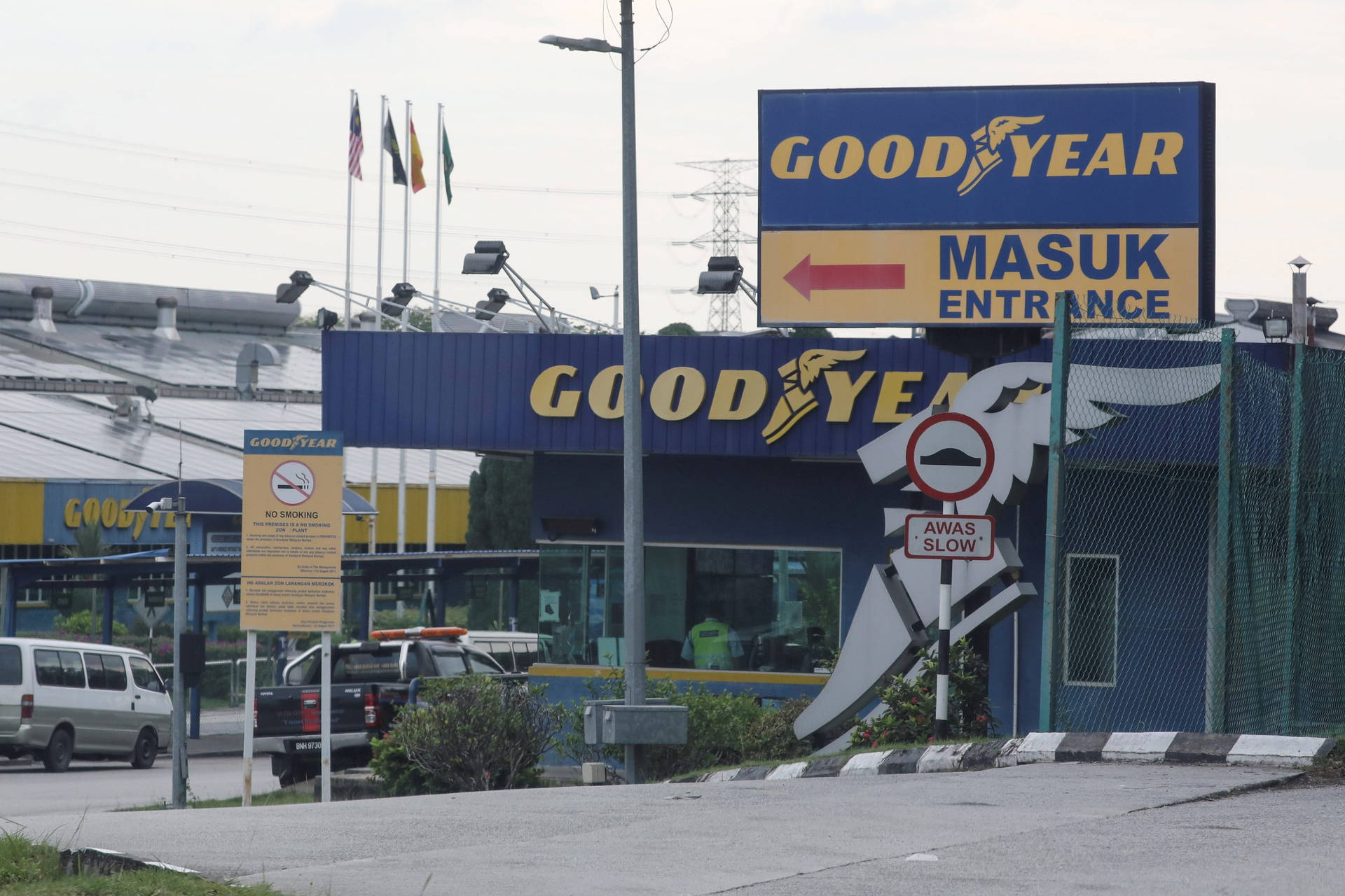 帶有停放車輛和旗幟的Goodyear輪胎店入口。