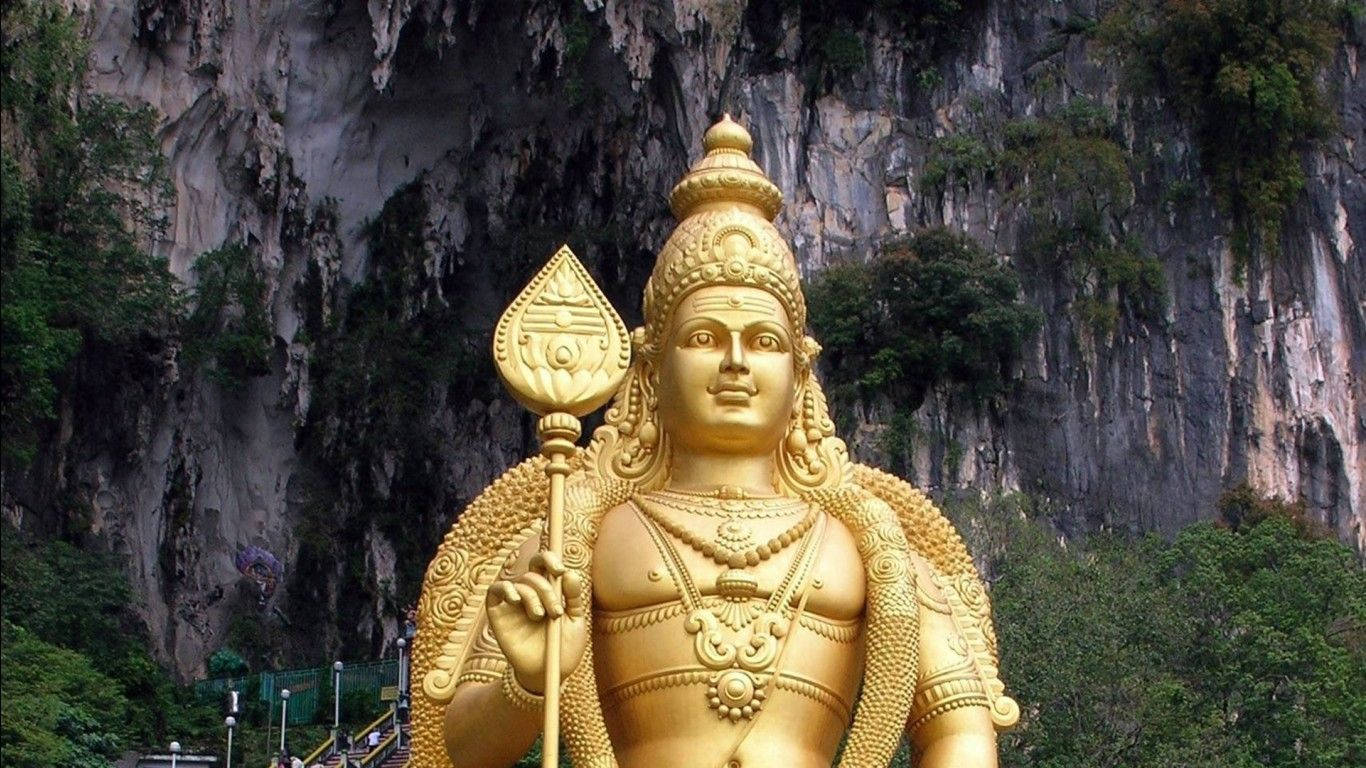 綠意環繞的山間寺廟中的金色印度教神像。