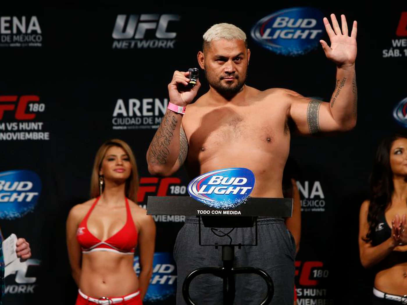 UFC拳手喺稱重活動中，旁邊有兩位著比堅尼嘅擂台女郎。
