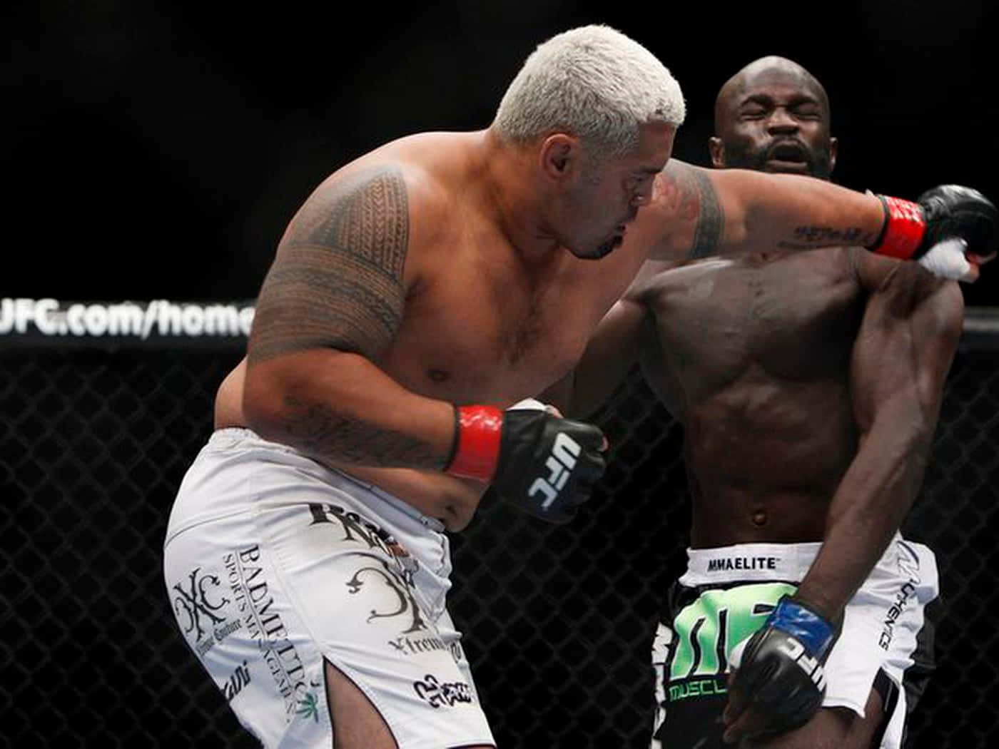 兩名男性MMA拳手在八角籠內比賽中互相出拳。