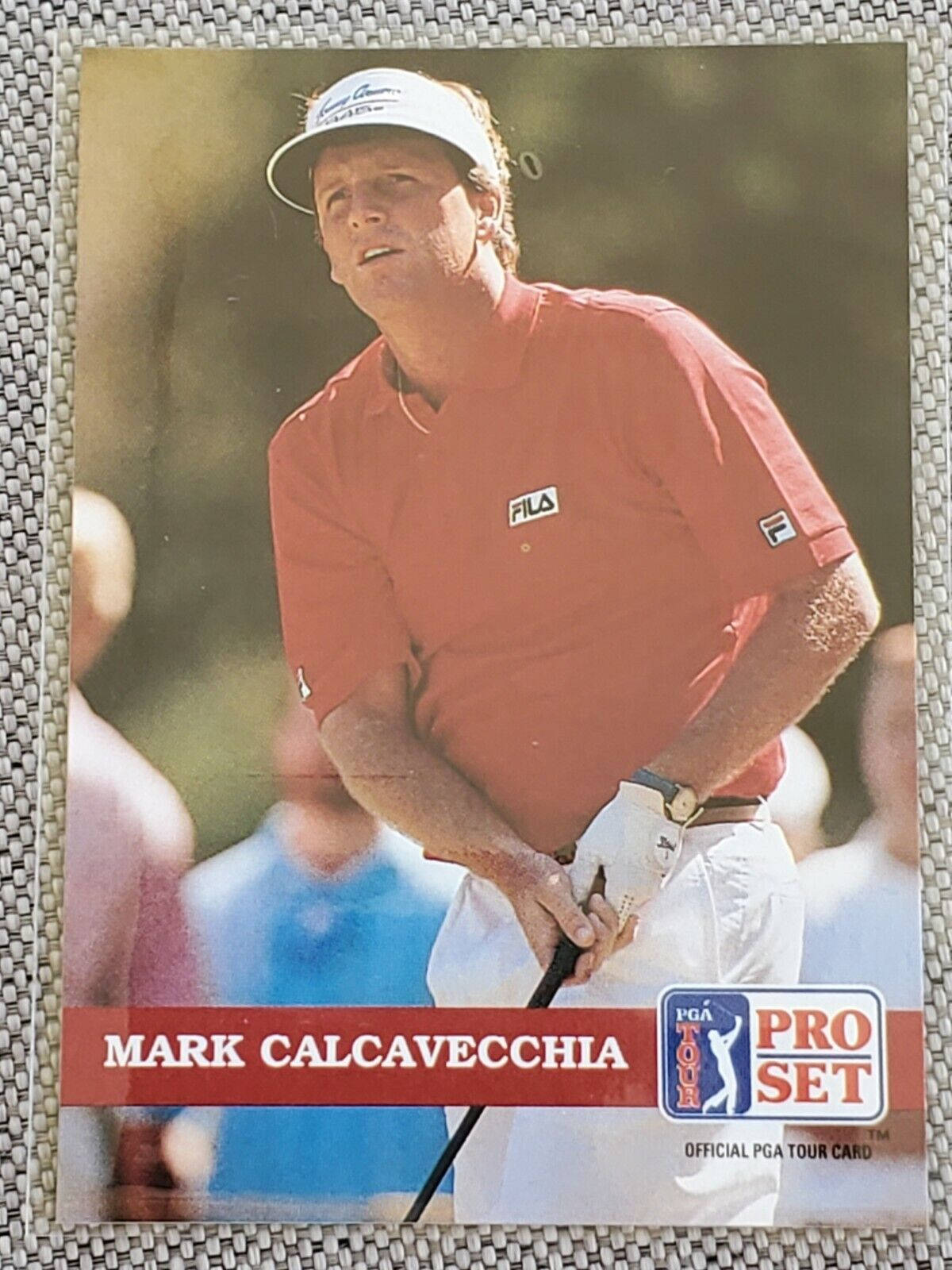馬克·卡爾卡維奇職業賽系列照 壁紙 — 高爾夫球手 Mark Calcavecchia 身穿紅色 FILA 襯衫和白色帽子，在陽光明媚的 PGA 巡迴賽卡上專注地揮桿。