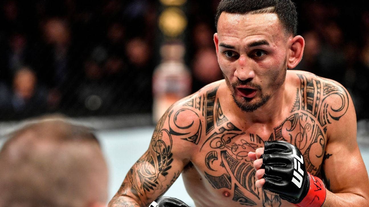 紋身的MMA選手戴著手套在UFC比賽中專注地凝視。