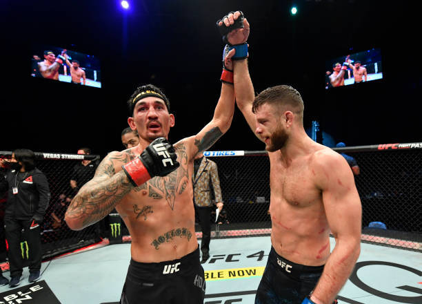 兩名MMA拳手在UFC八角籠內舉手慶祝勝利。
