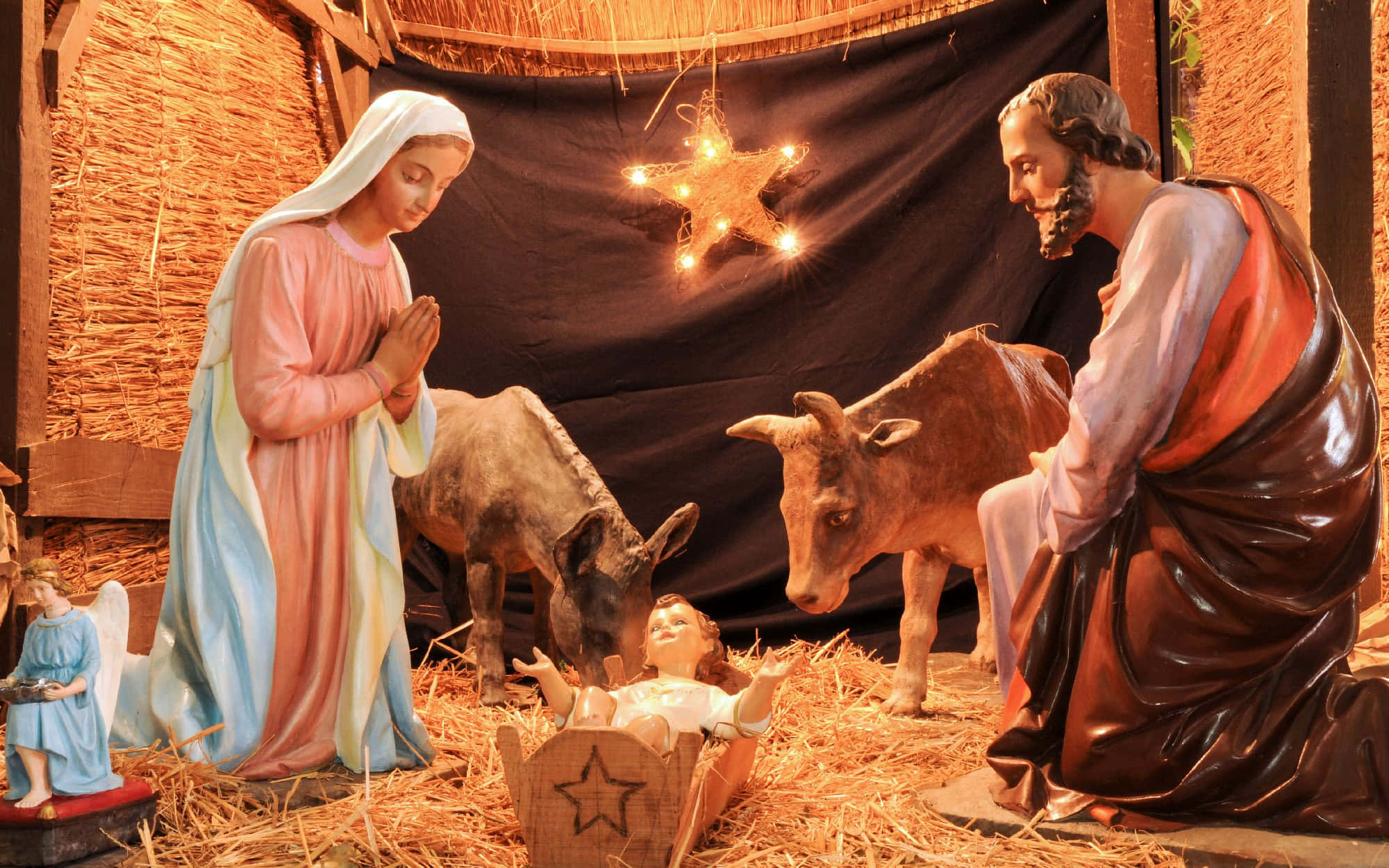 Nativity 桌布 壁紙 — 馬利亞和約瑟跪在馬槽旁的耶穌嬰孩身邊，周圍有動物和一顆閃耀的星星的聖誕場景。