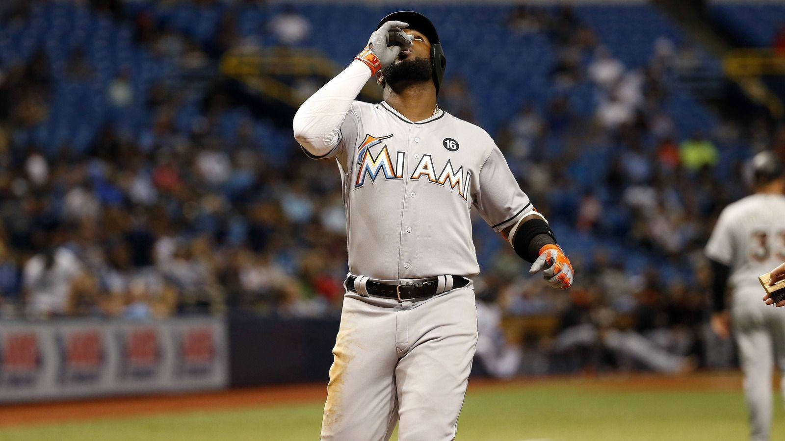 棒球選手在夜間比賽中於體育場燈光下擦拭汗水。