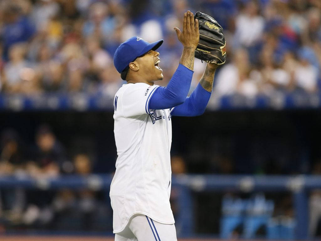 棒球選手在夜間球場高舉雙臂慶祝勝利。
