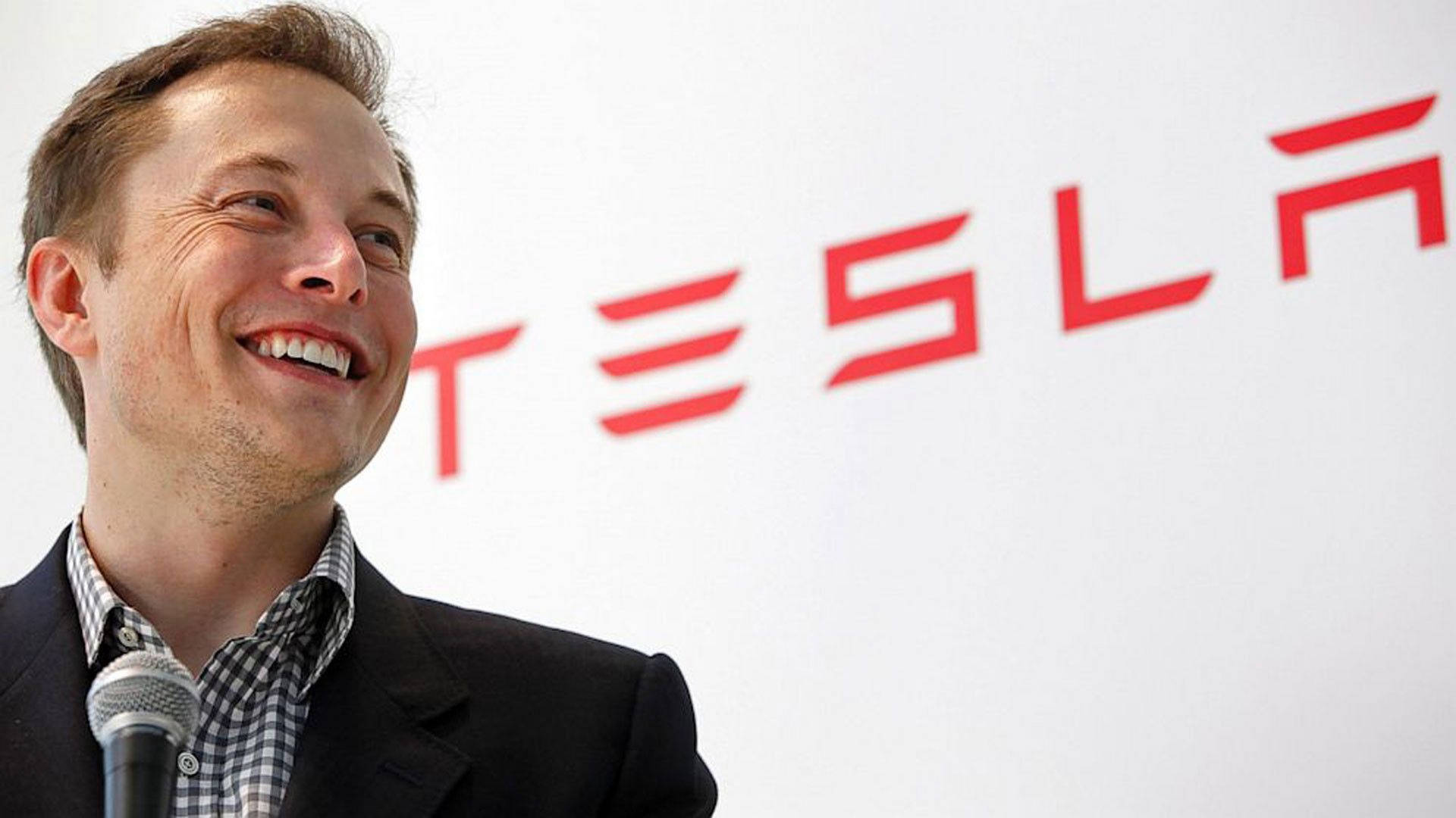 Elon Musk 在 Tesla 活動中微笑並手持麥克風 — 馬斯克 壁紙