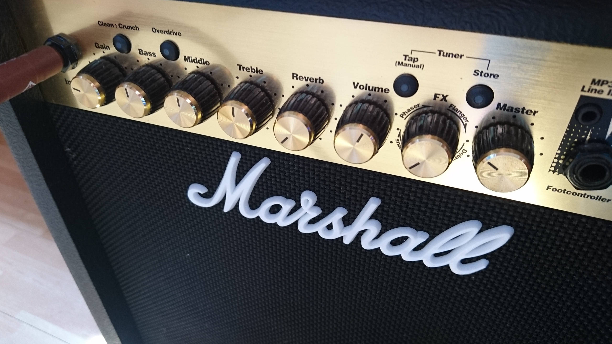 馬歇爾吉他音箱特寫攝影 壁紙 — Marshall 結他擴音器特寫，黑色網布上有旋鈕和標誌。