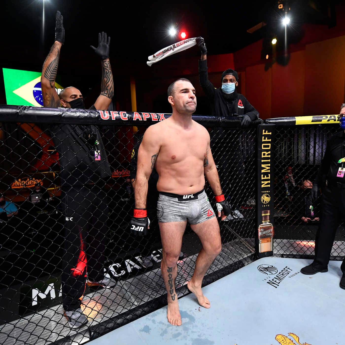 UFC拳手在八角籠中舉臂慶祝勝利。