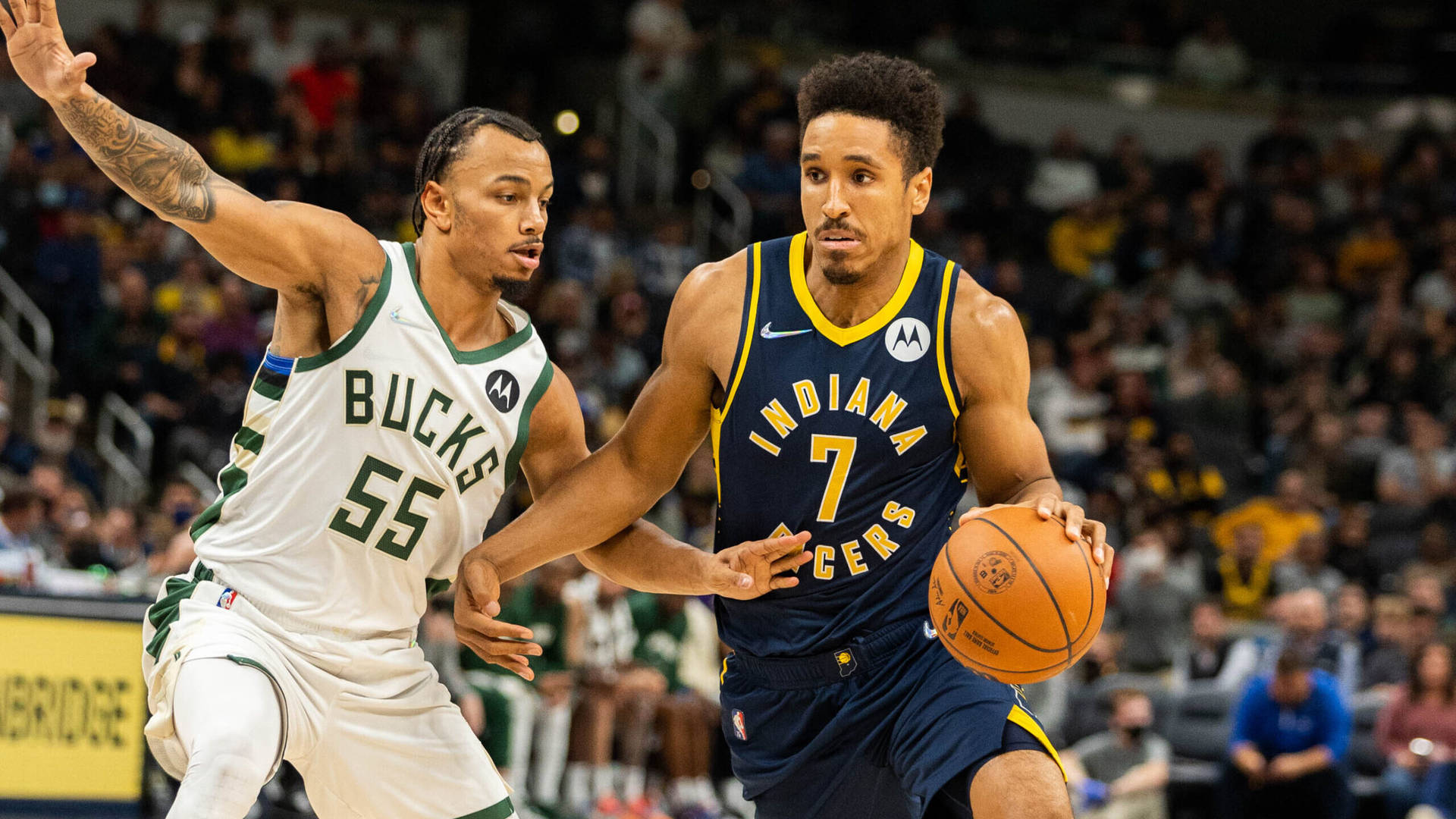 兩名NBA籃球運動員在比賽中，背景有觀眾。