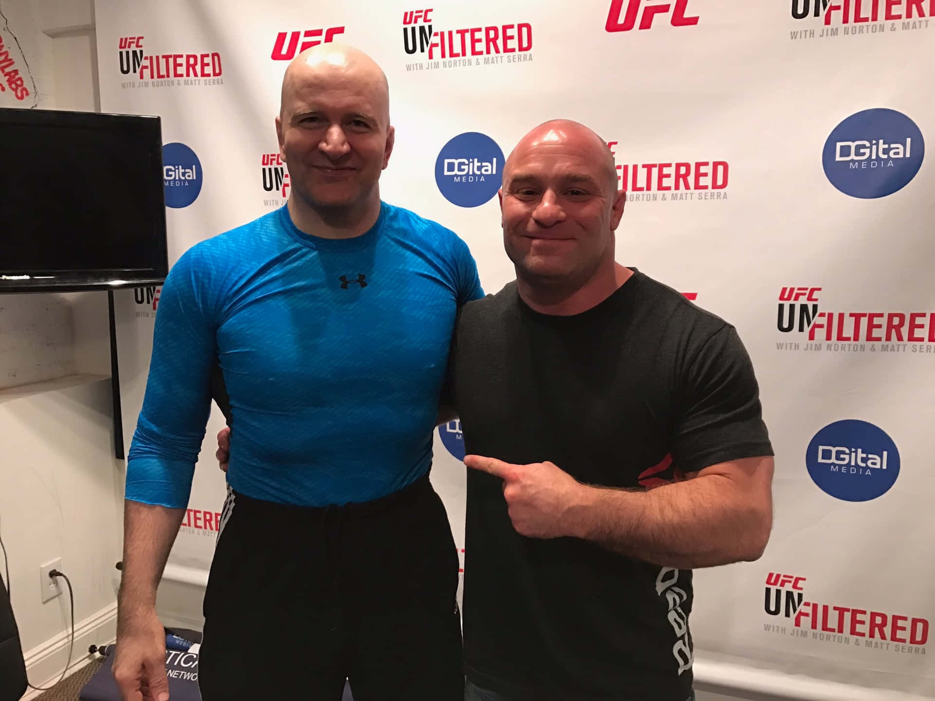 兩名光頭男子穿著運動服在UFC活動中擺姿勢拍照。