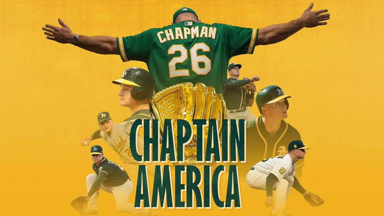 馬特·查普曼化身「Chaptain America」 壁紙 — 一名身穿綠色球衣的棒球運動員，雙臂伸展在隊友上方，手持金色手套，黃色背景上有「CHAPTAIN AMERICA」文字。