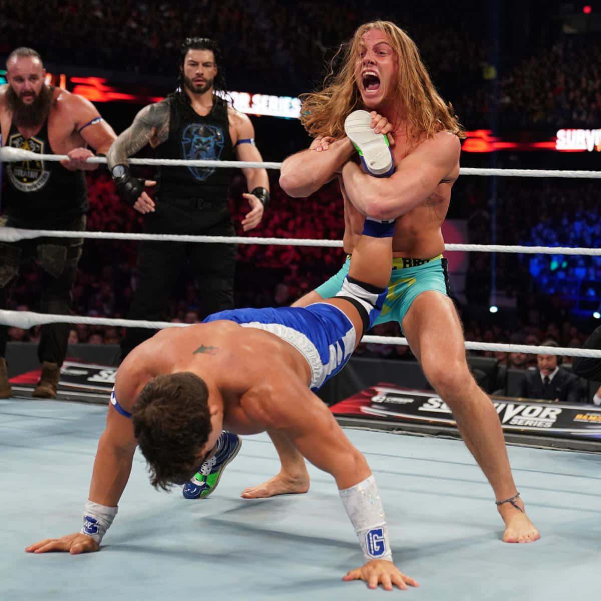摔角手在 Survivor Series 比賽中，背景有觀眾，正在進行動作。