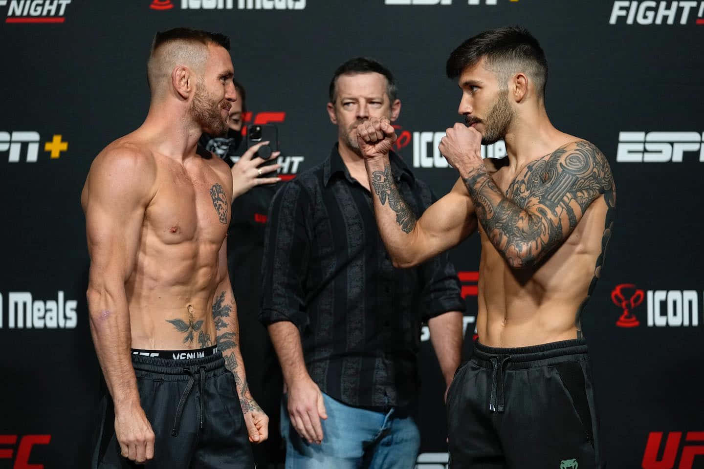 兩名赤裸上身的MMA拳手在帶有ESPN標誌的過磅活動中拳頭相抵。