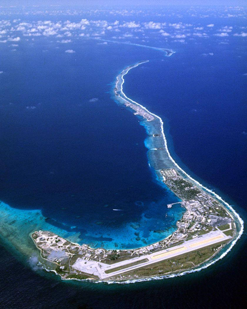 一個長島的鳥瞰圖，設有機場跑道，周圍環繞著碧綠潟湖和深藍色海洋。