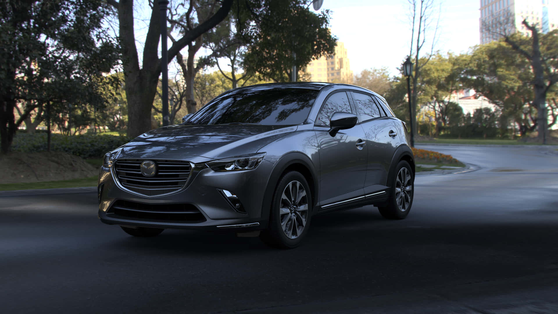 馬自達CX-3城市駕駛 壁紙 — 一架時尚的灰色Mazda CX-3 SUV停泊在綠樹成蔭的城市道路上，背景是現代建築。