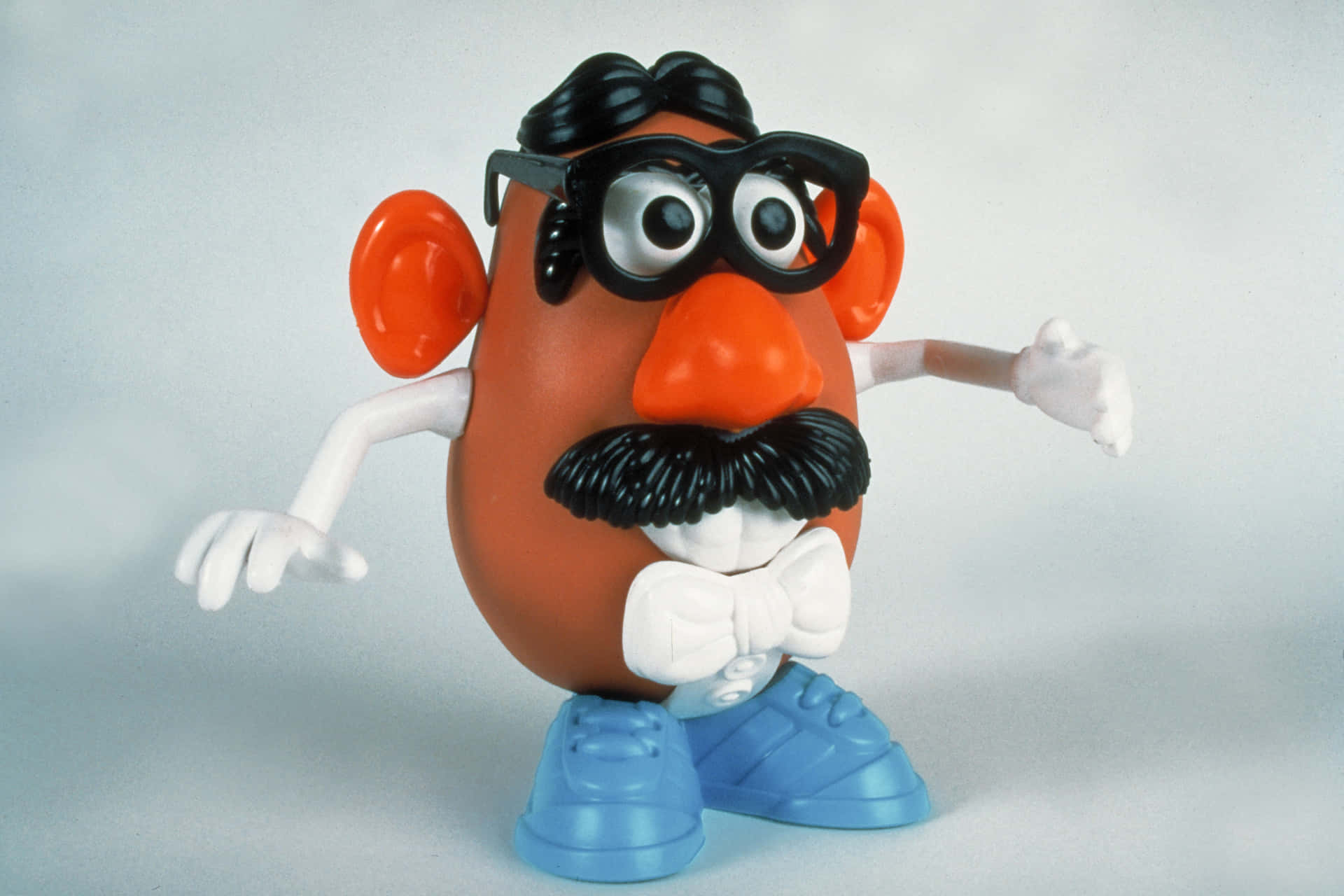Mr. Potato Head 玩具戴著眼鏡、鬍子、領結和藍色鞋子。