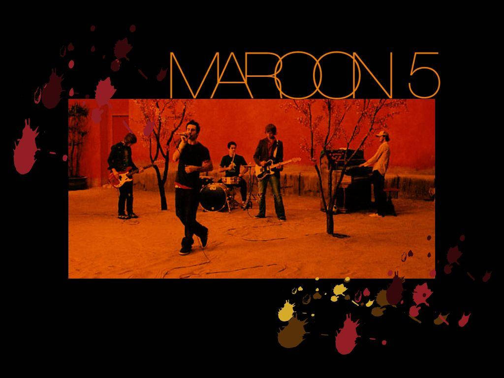 馬龍5龐克風格 壁紙 — Maroon 5 樂隊在黑色背景上以溫暖的橙色燈光和潑濺藝術點綴進行現場表演。