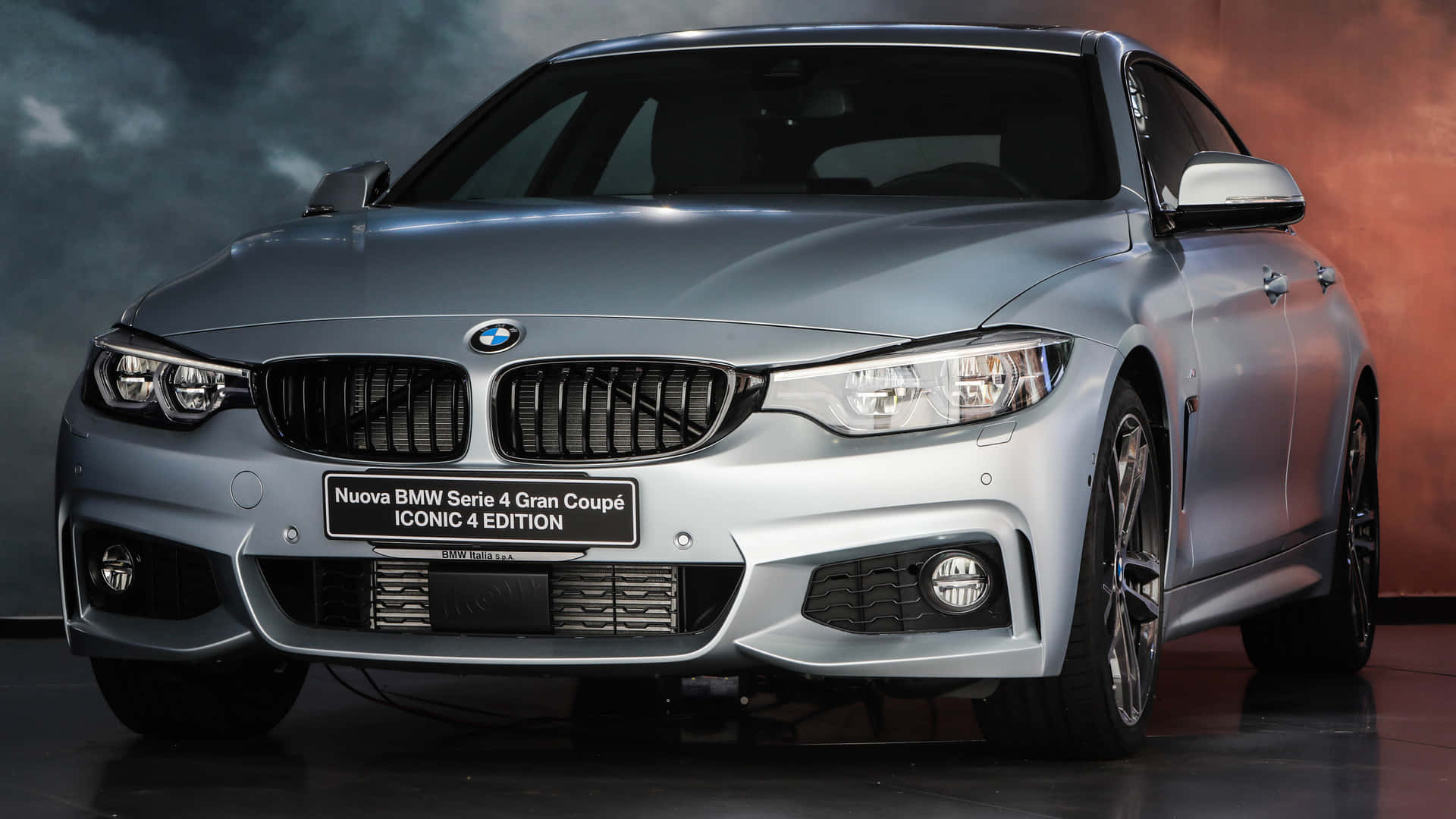 銀色BMW 4系Gran Coupé Iconic Edition在攝影棚中，帶有戲劇性燈光。