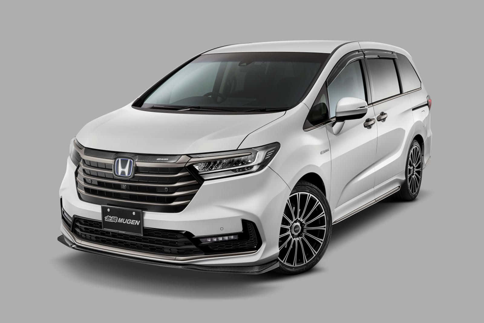 駕馭2023 Honda Pilot，充滿信心 壁紙 — 一架流線型白色本田Odyssey七人車，配備Mugen改裝飾件及黑色多幅式輪圈，背景為中性灰色攝影棚。