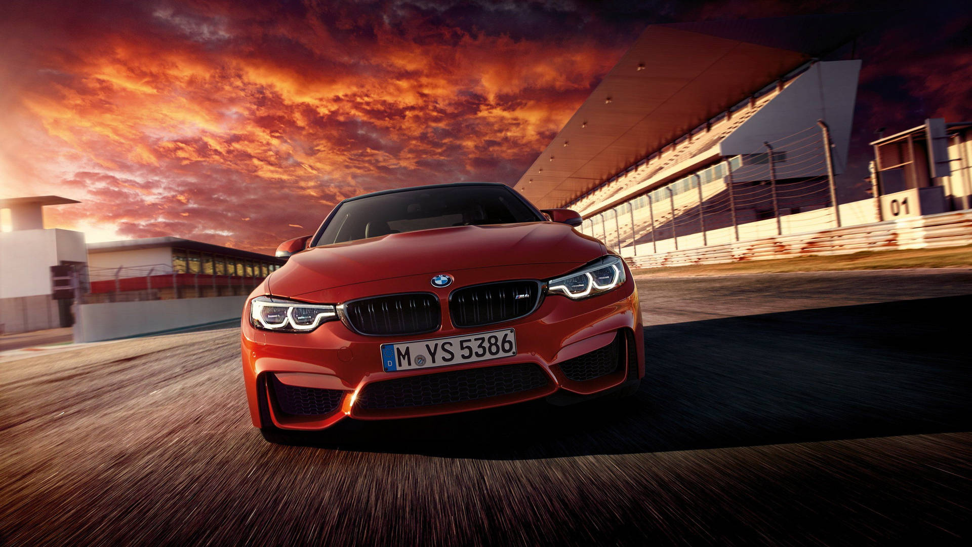 紅色BMW M4在日落時分的賽道上疾馳。
