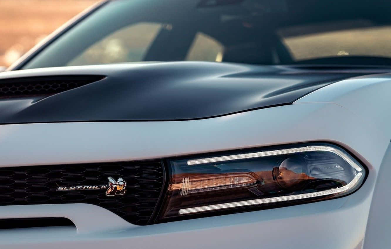 白色Dodge ScatPack車頭在日落時發光的頭燈。