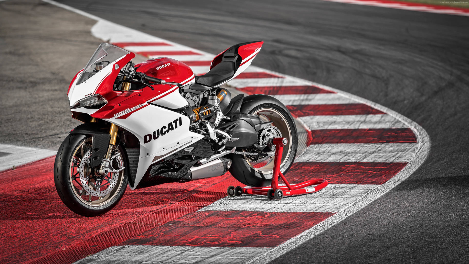 紅白相間的Ducati電單車在賽道上，帶有紅白相間的賽道邊緣。