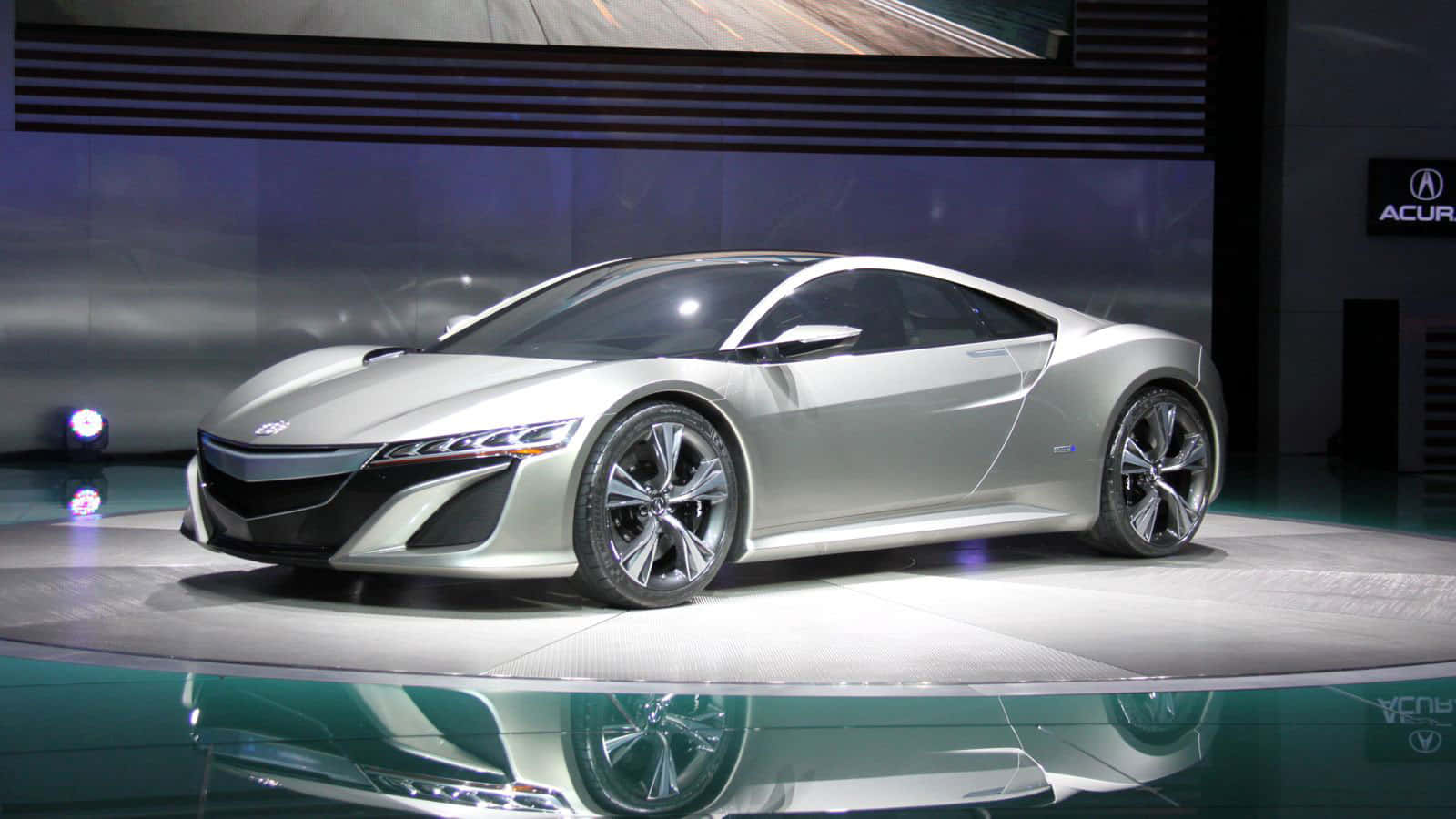 車展上反光舞台上的銀色跑車，聚光燈照射。