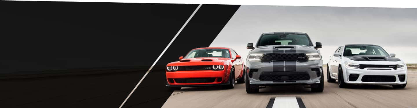 三輛 Dodge 肌肉車在賽道上一字排開。