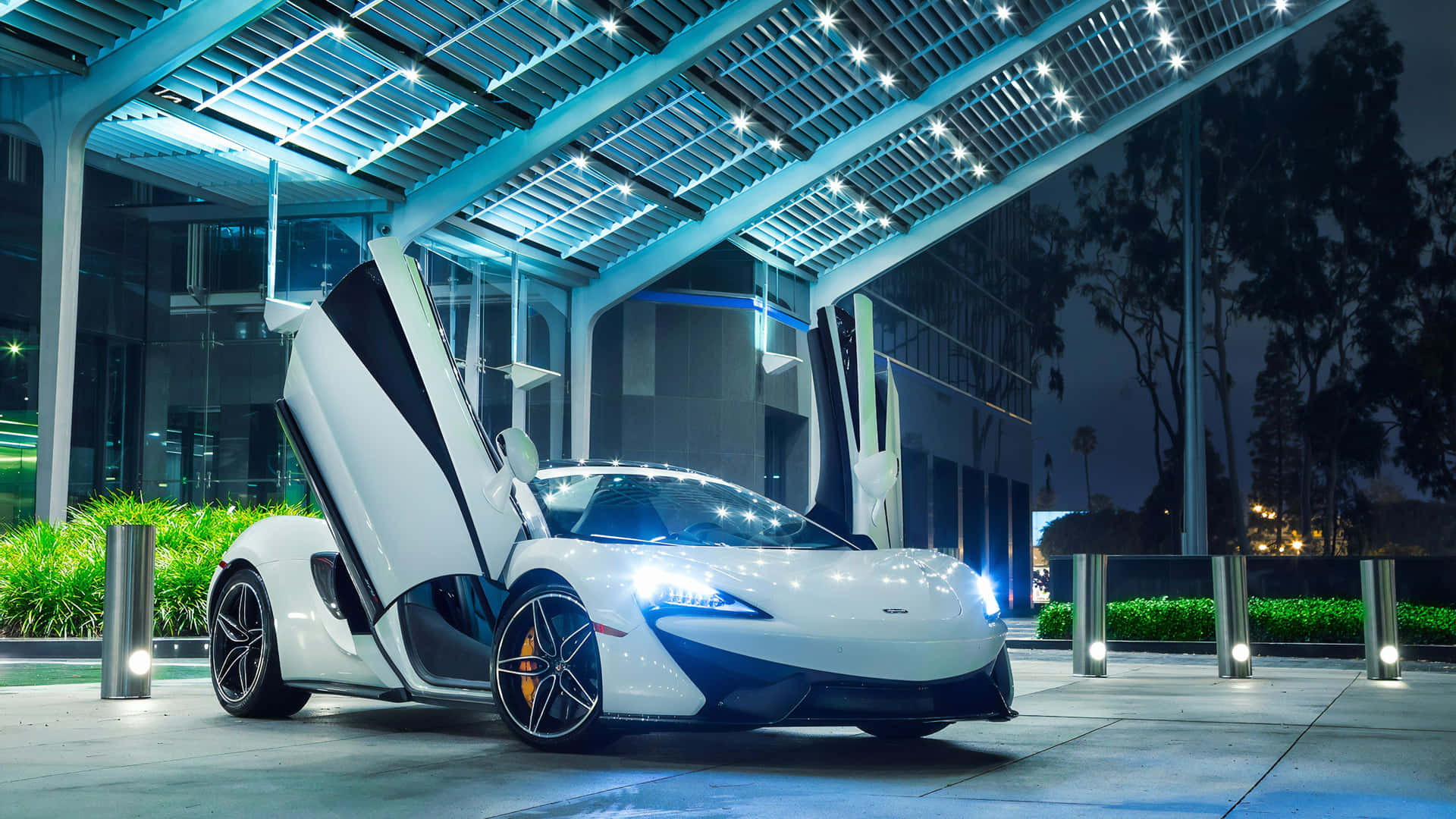 夜間，白色McLaren跑車在藍色照明天篷下打開車門。