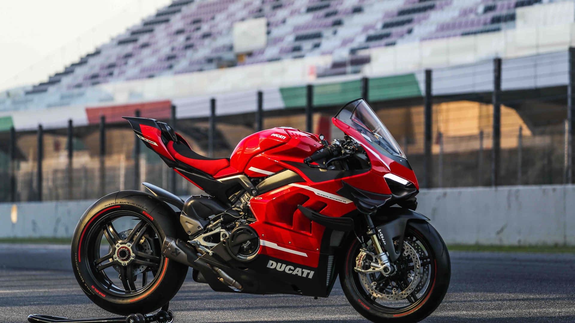 紅色Ducati運動電單車在日落時停泊在賽道上。