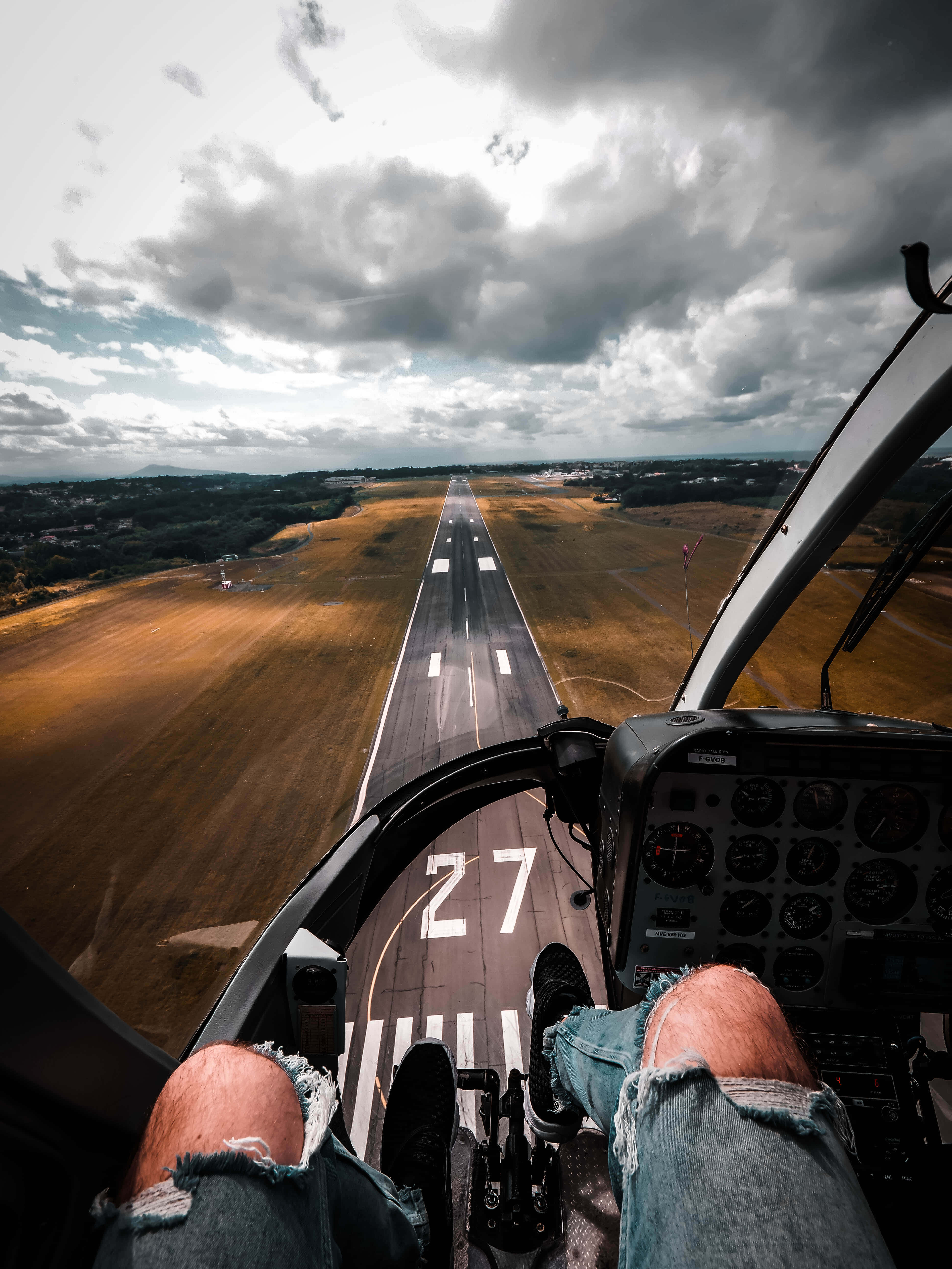 駕駛員降落跑道視角 壁紙 — 從小型飛機駕駛艙內以第一人稱視角，在戲劇性的多雲天空下滑行至27號跑道。