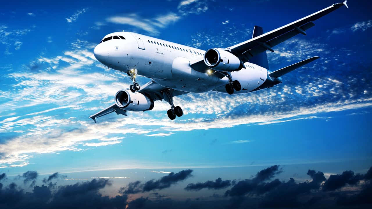 駕駛私人飛機穿雲而過 壁紙 — 一架白色客機在湛藍的天空中翱翔，伴隨著散落的雲朵和發光的引擎。