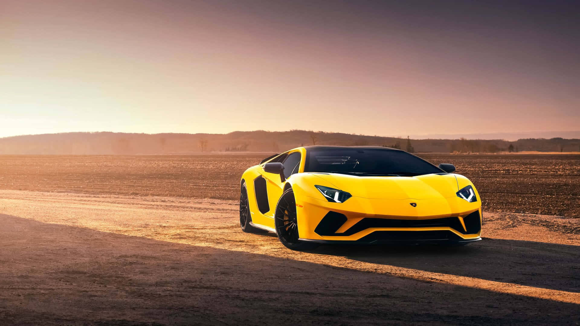 金色夕陽下土路上的黃色林寶堅尼 Aventador