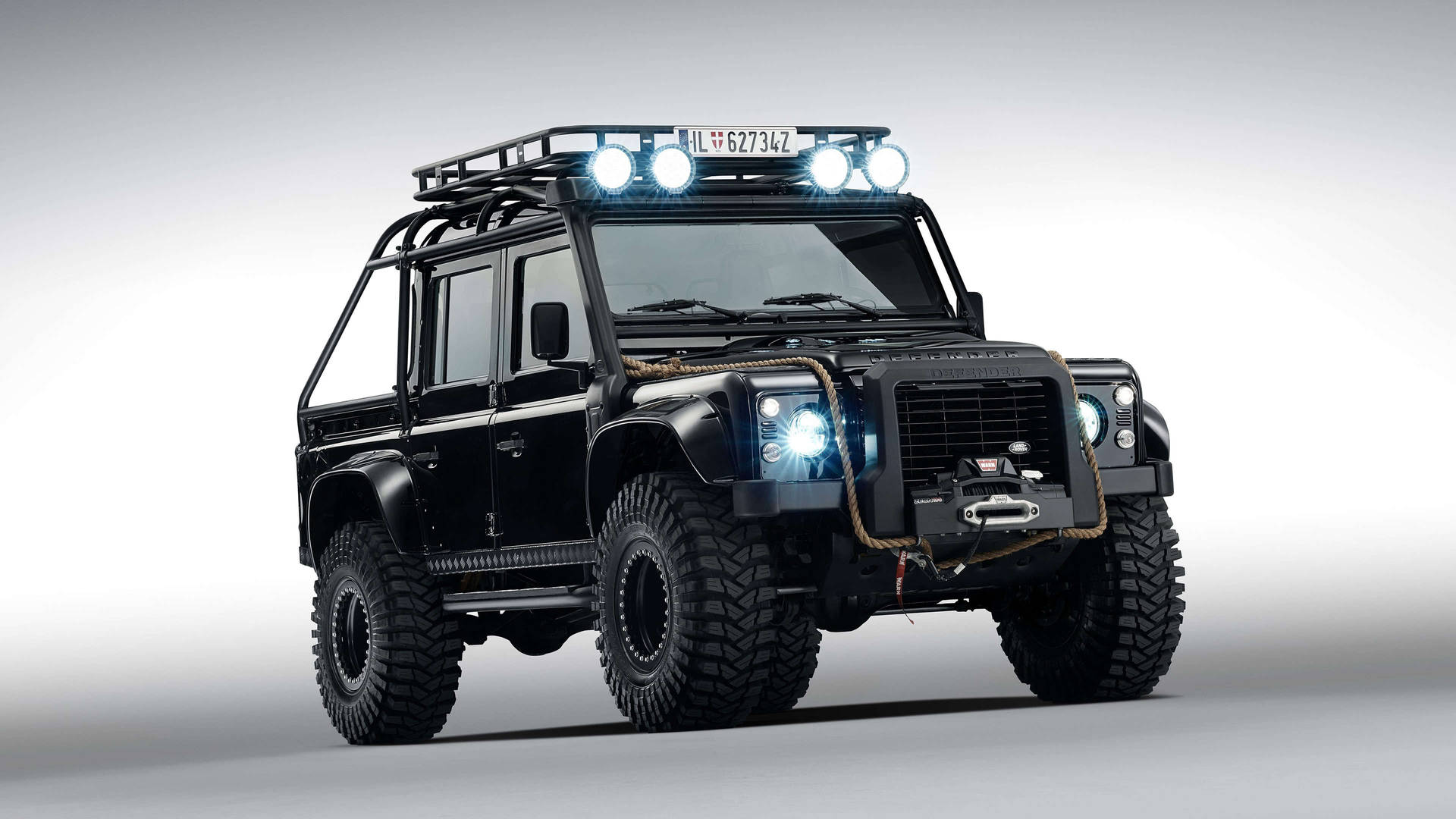 黑色Land Rover Defender在工作室環境中配備車頂燈和堅固輪胎