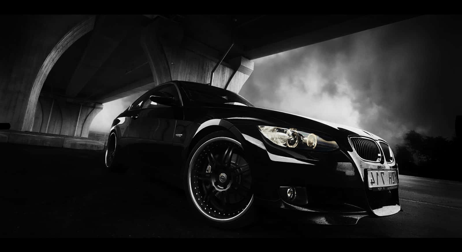 黑色BMW汽車在混凝土天橋下漂移，伴有煙霧和戲劇性照明。