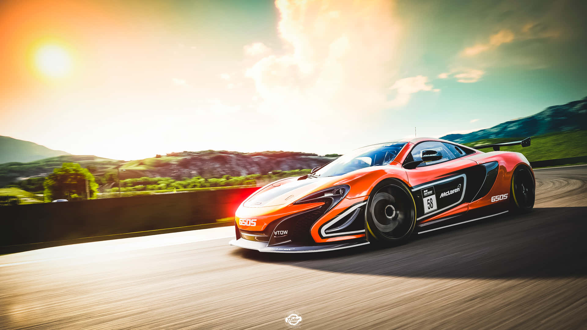 橙色McLaren 650S賽車在日落時分的山路上奔馳。