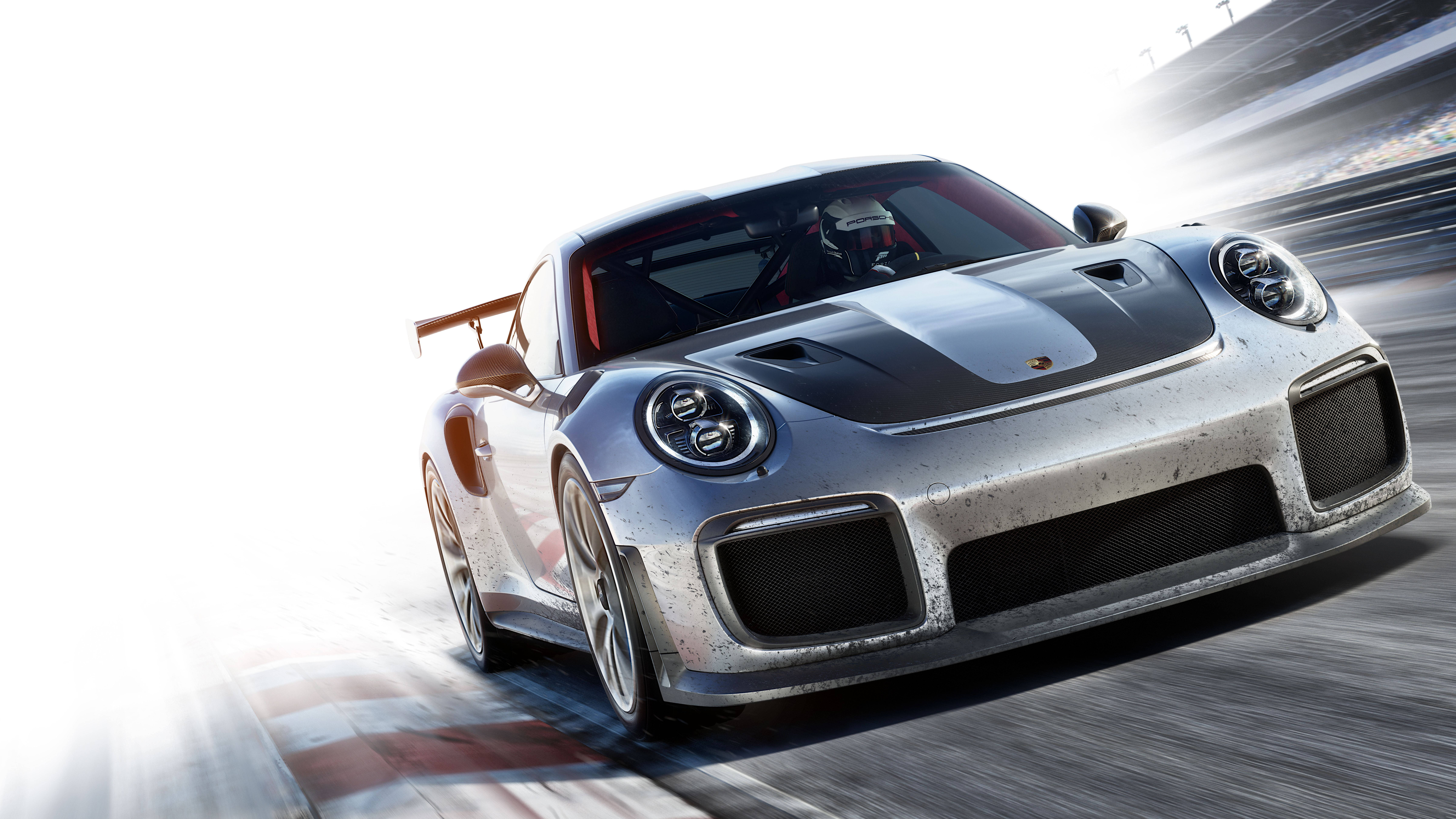 駕駛這款驚人Forza跑車 壁紙 — 一輛銀色保時捷911 GT2 RS在賽道上高速飛馳，帶有動態模糊和明亮陽光。
