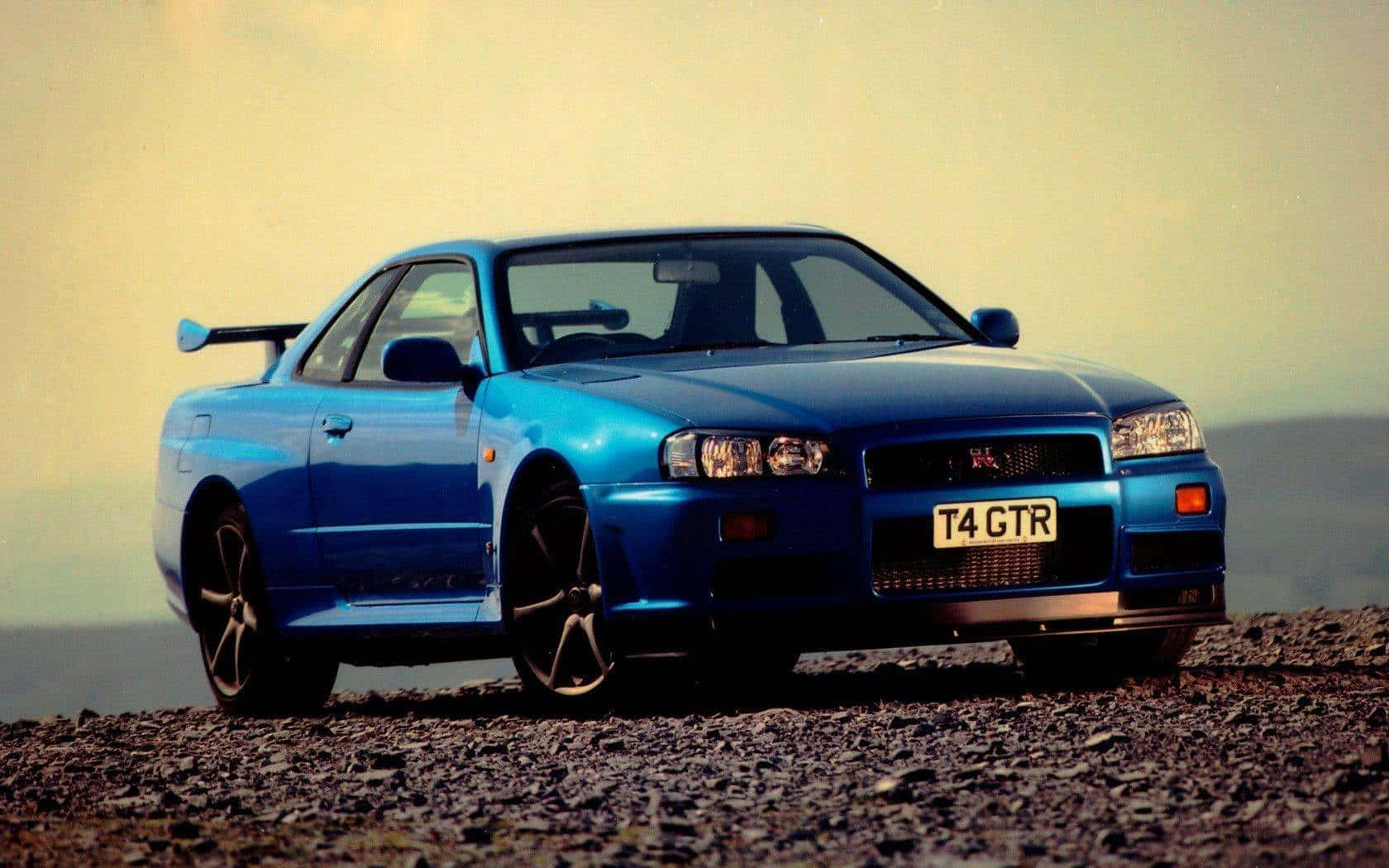 日落時分碎石路上的藍色日產Skyline GTR。