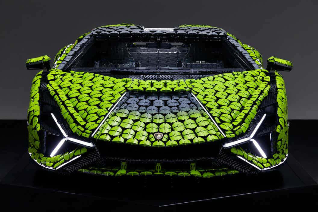 駕駛酷炫蘭博基尼 壁紙 — 一輛充滿活力的青檸綠色LEGO林寶堅尼Aventador，帶有發光的白色頭燈和黑色飾邊，在深色工作室背景前展示。