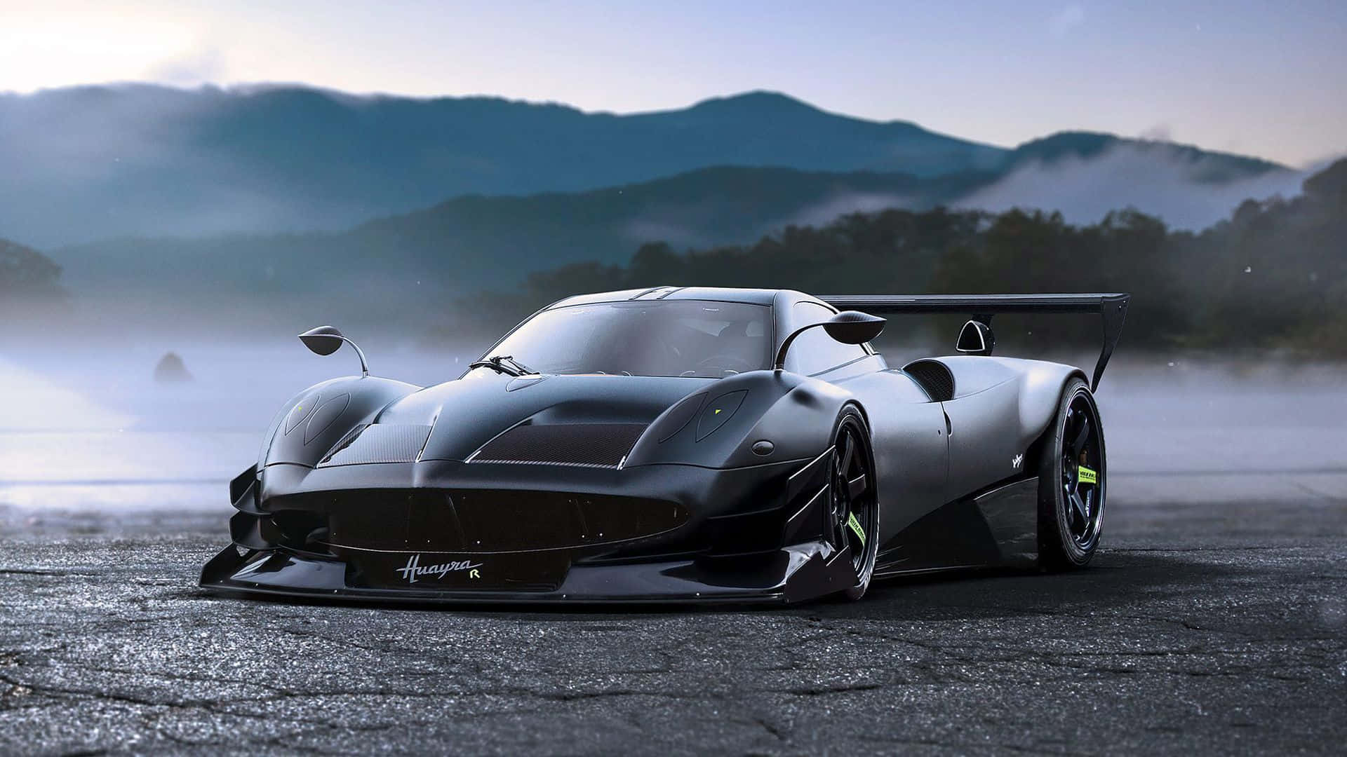 啞光黑色Huayra Roadster在潮濕賽道上漂移，背景有霧氣繚繞的山脈。