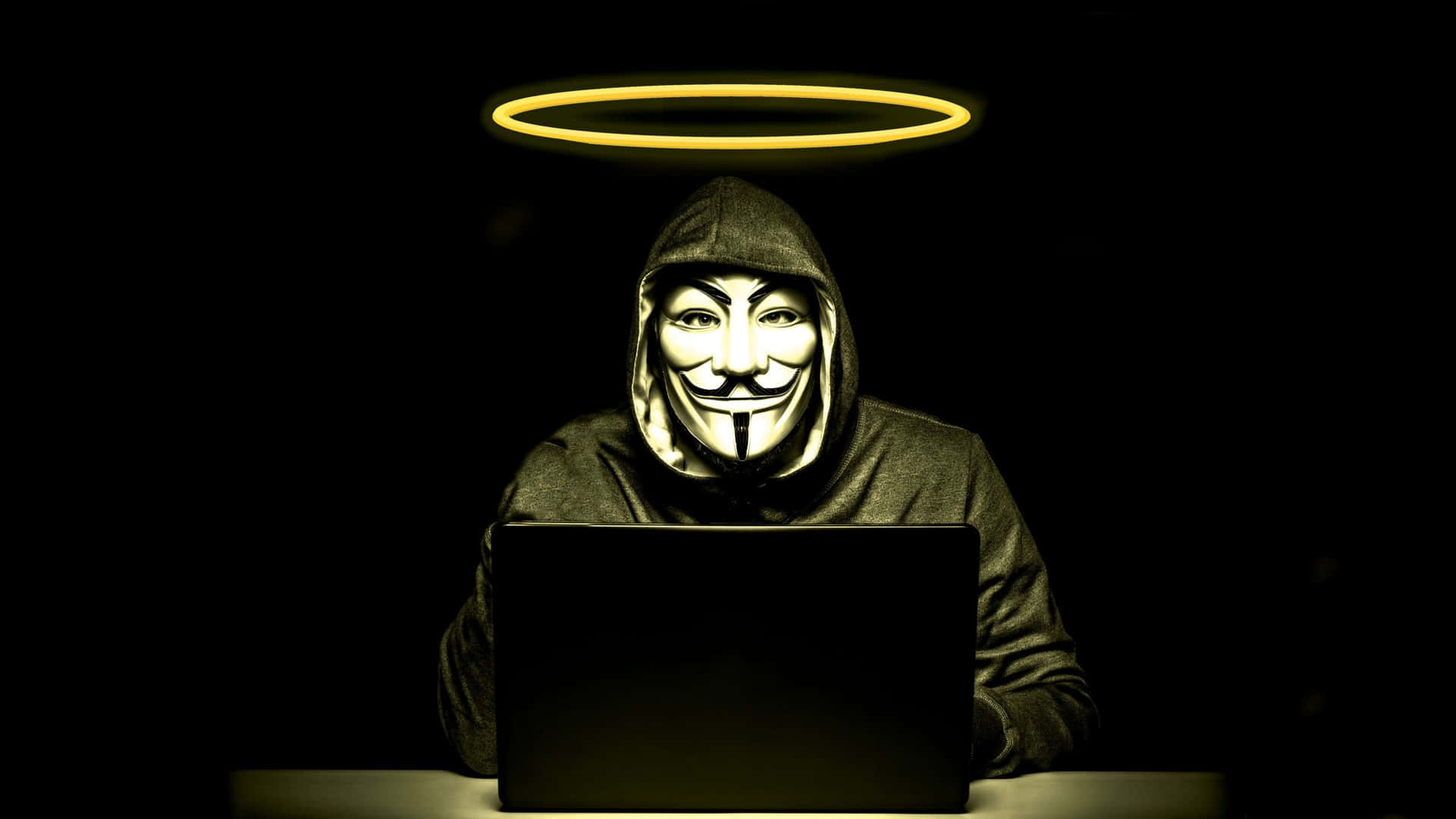 戴著蓋伊·福克斯面具和光環的人坐在黑暗房間裡的手提電腦前。