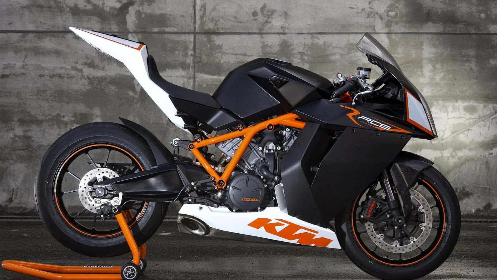 型格黑色橙色KTM RC8電單車，混凝土牆前。