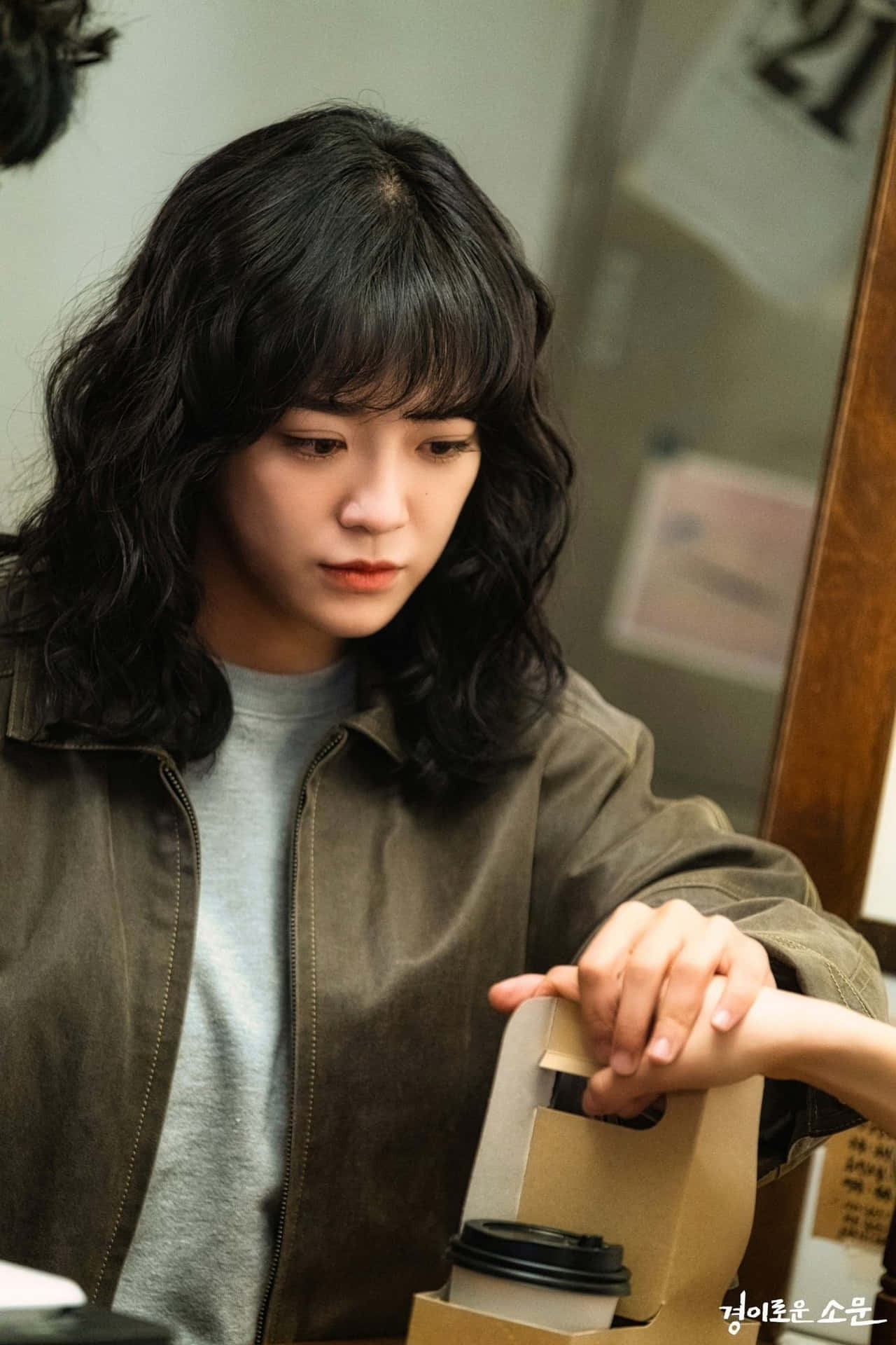 年輕女性在室內專注地拿著咖啡袋
