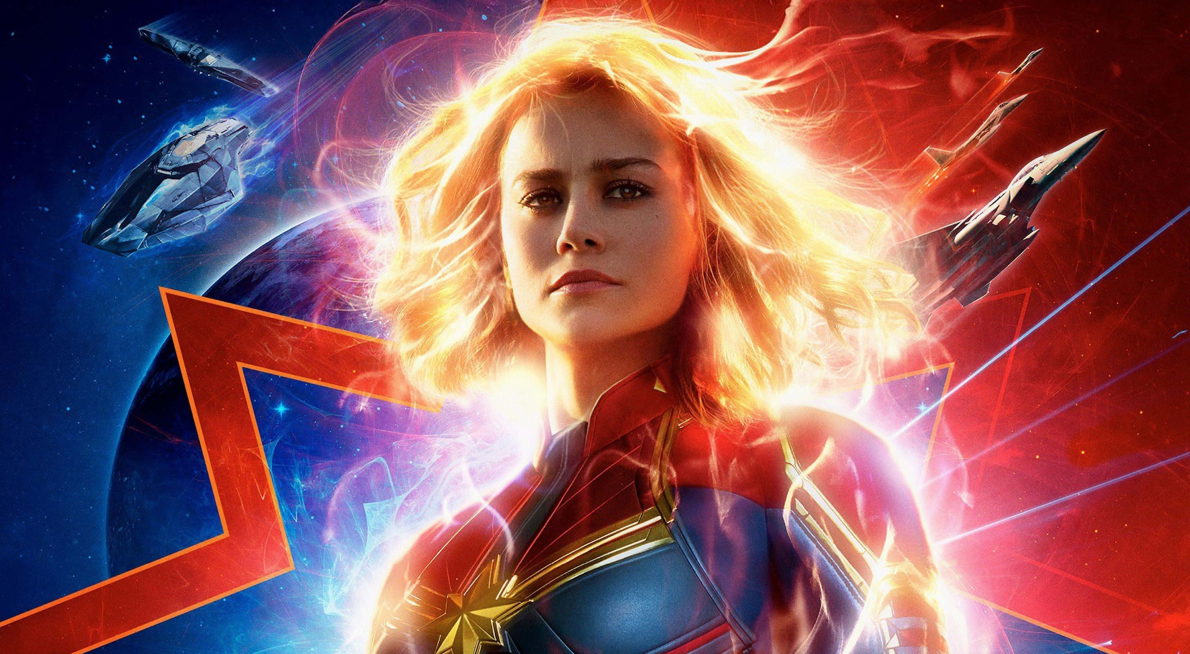 4K Marvel 壁紙 桌布 壁紙 — 驚奇隊長在太空中英勇地站著，周圍有發光的能量和未來風格的飛船環繞。