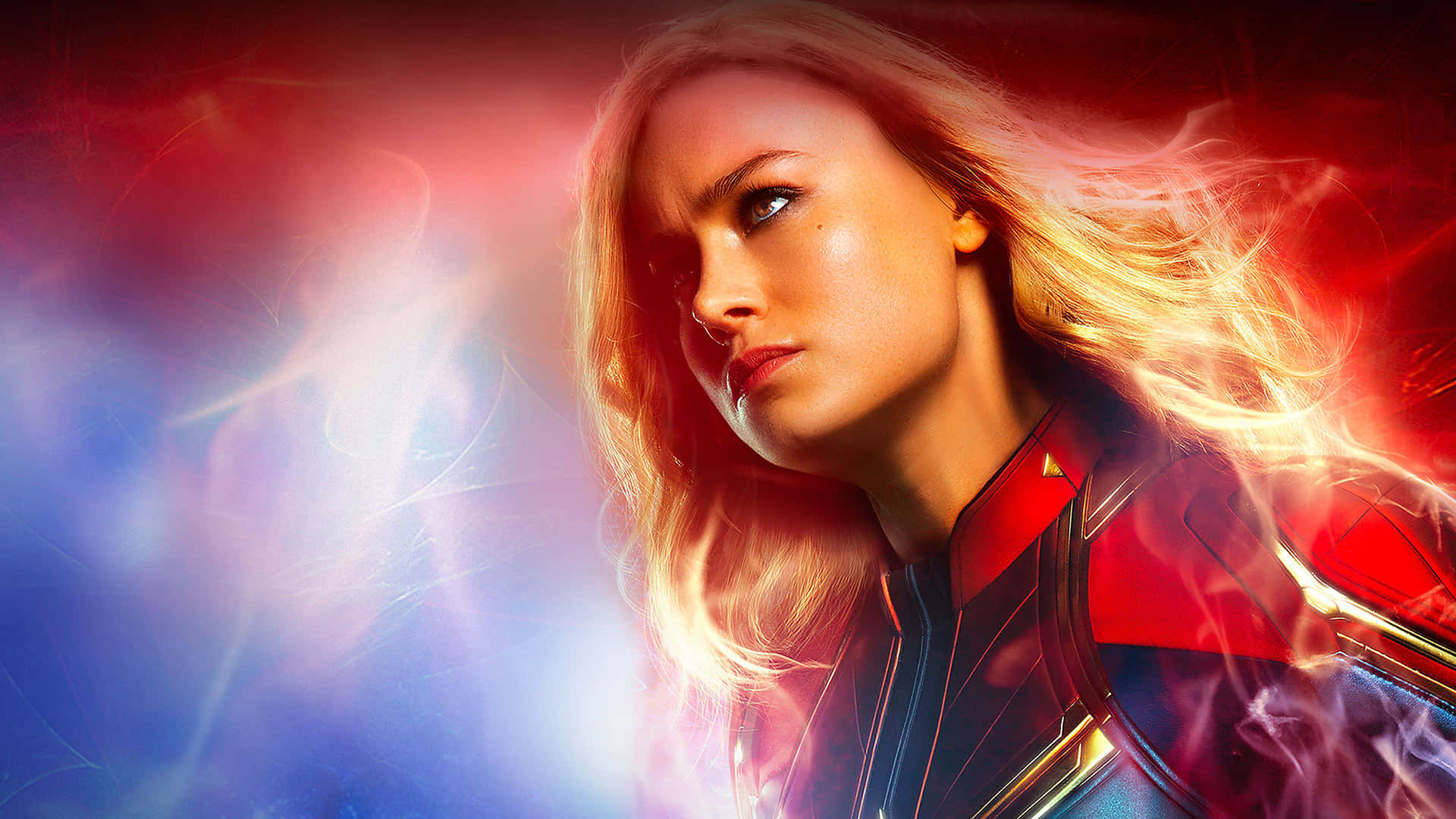 Captain Marvel HD 桌布 壁紙 — 驚奇隊長身穿紅藍戰衣，發光的能量在她周圍旋轉，背景是充滿活力的紅藍宇宙背景。