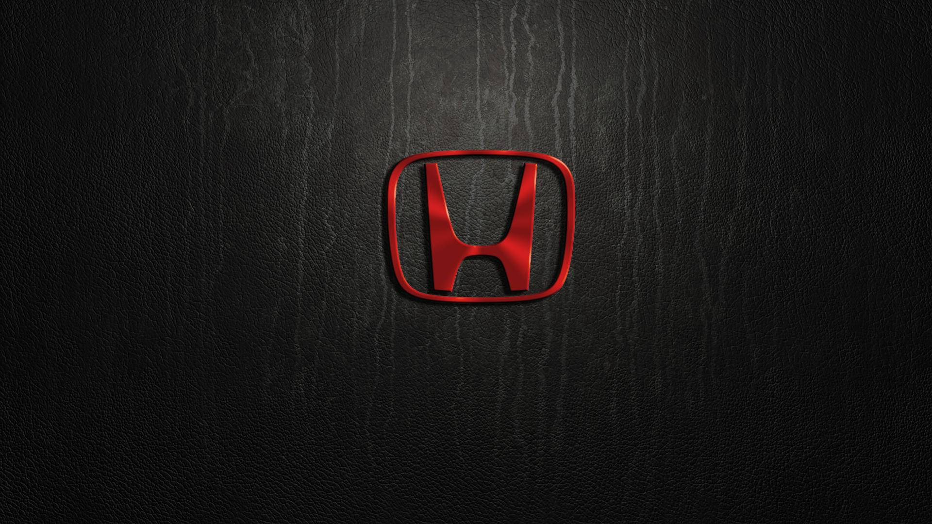 深色紋理皮革背景上的紅色Honda標誌。