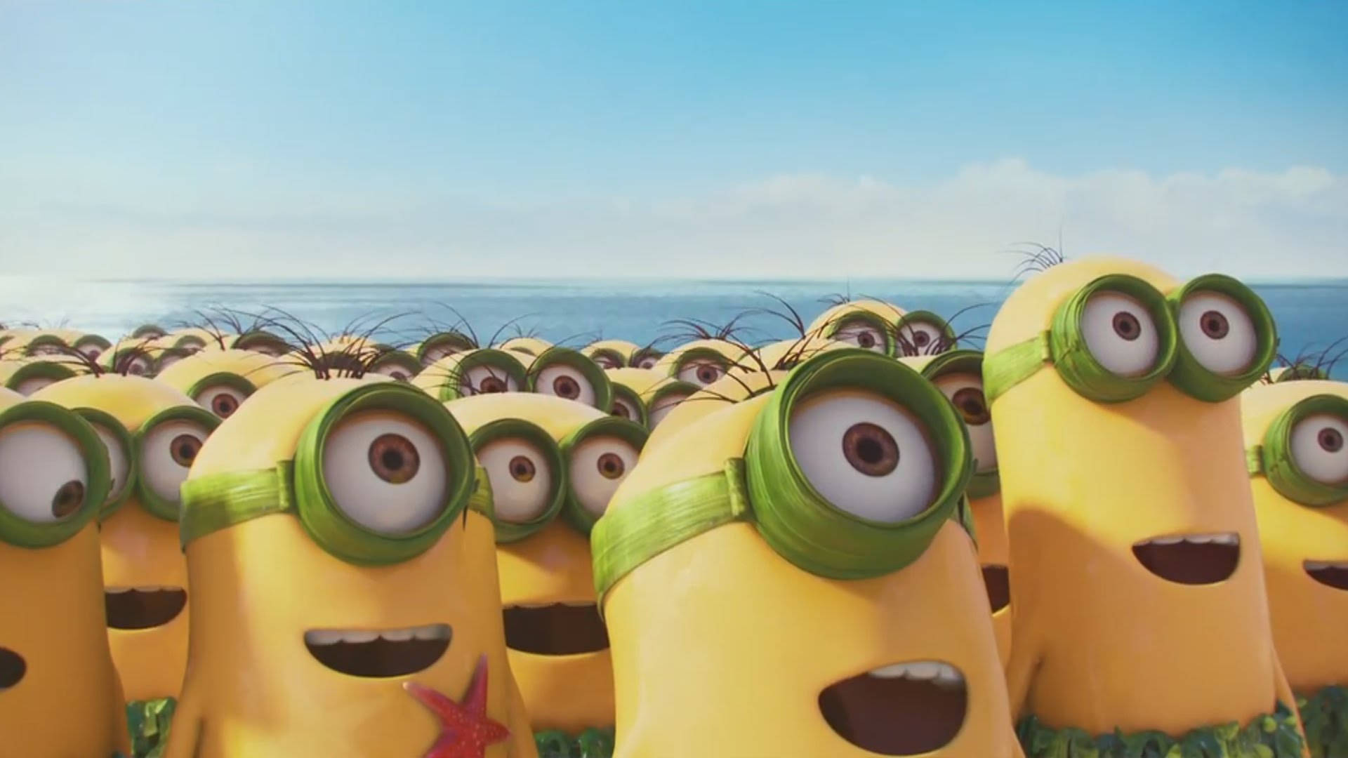 戴綠色護目鏡嘅黃色Minions喺藍天下企喺海邊草地上