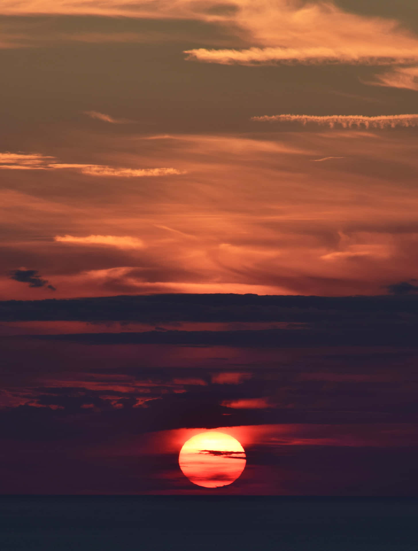 海洋日落，天空呈現橙色和紫色